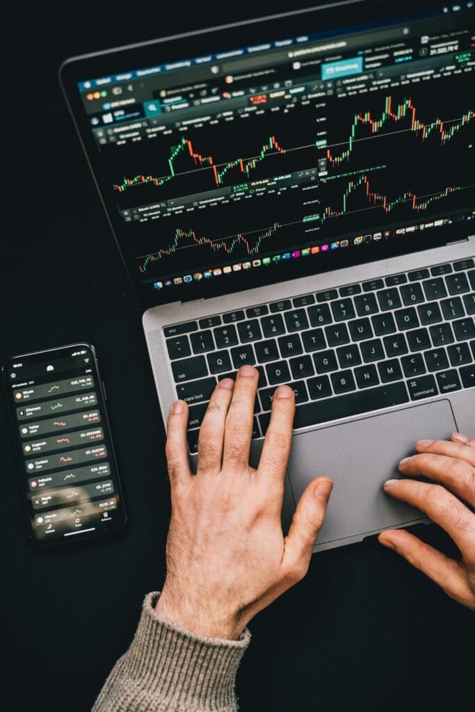 man aan het typen op laptop, beurs aan het checken